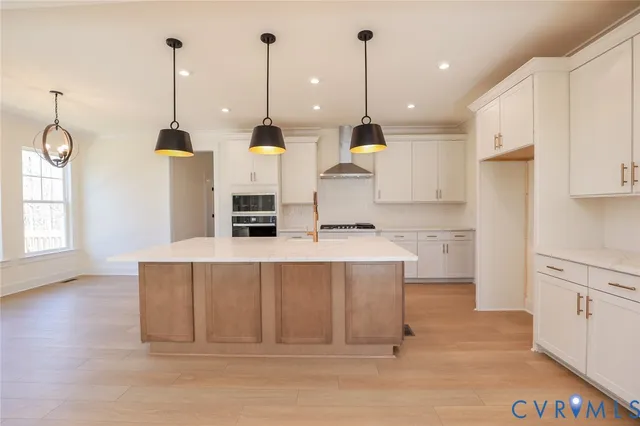 a kitchen with kitchen island a stove a counter space and a view of living room