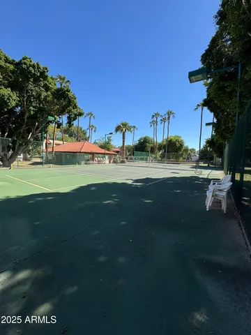 a view of grassy field with building and trees in the background
