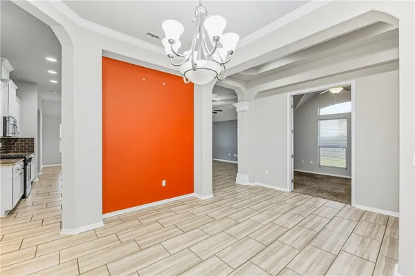 a view of a hallway with wooden floor and chandelier