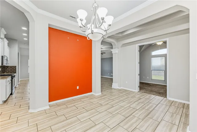 a view of a hallway with wooden floor and chandelier