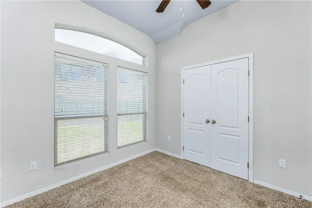an empty room with windows and closet