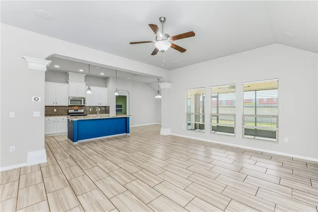 a view of kitchen with granite countertop cabinets and window