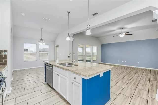 a hall with kitchen island granite countertop a sink and a stove