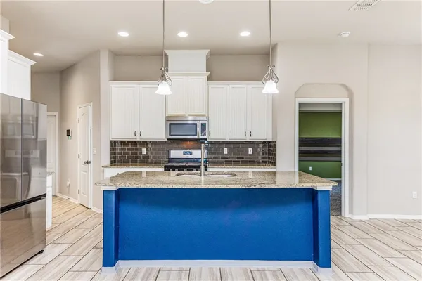 a kitchen with kitchen island granite countertop wooden cabinets and stainless steel appliances