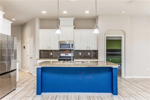 a kitchen with kitchen island granite countertop wooden cabinets and stainless steel appliances