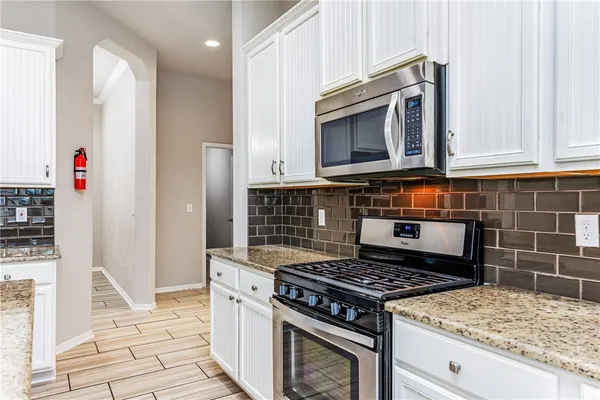 a stove top oven sitting inside of a kitchen