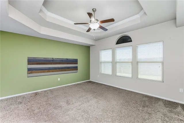 an empty room with windows and ceiling fan