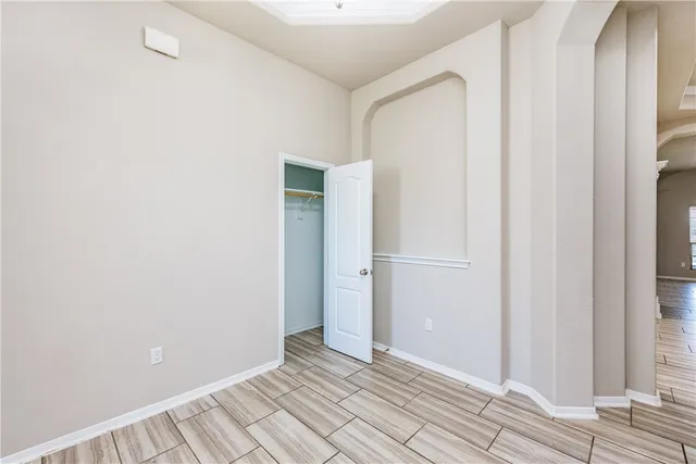 a view of an empty room with wooden floor