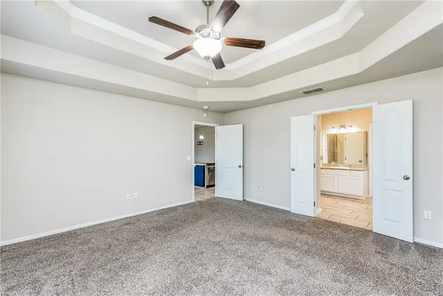a view of an empty room and a ceiling fan