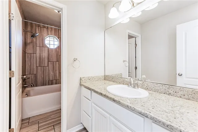 a bathroom with a granite countertop sink and a mirror
