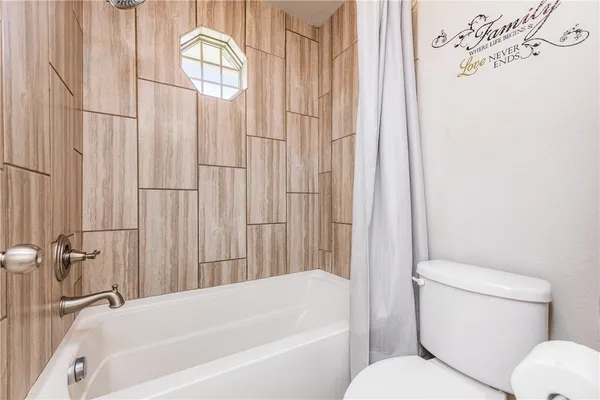 a bathroom with a toilet and a bathtub