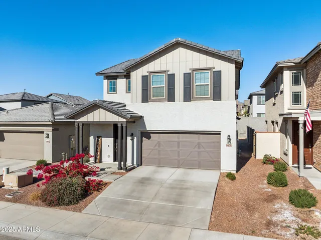 a view of a white house with a big yard and potted plants
