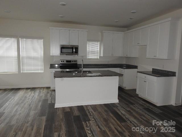 252 Mills Avenue Troutman, NC 28166 - Photo 4 of 15 a kitchen with wooden floors and black appliances