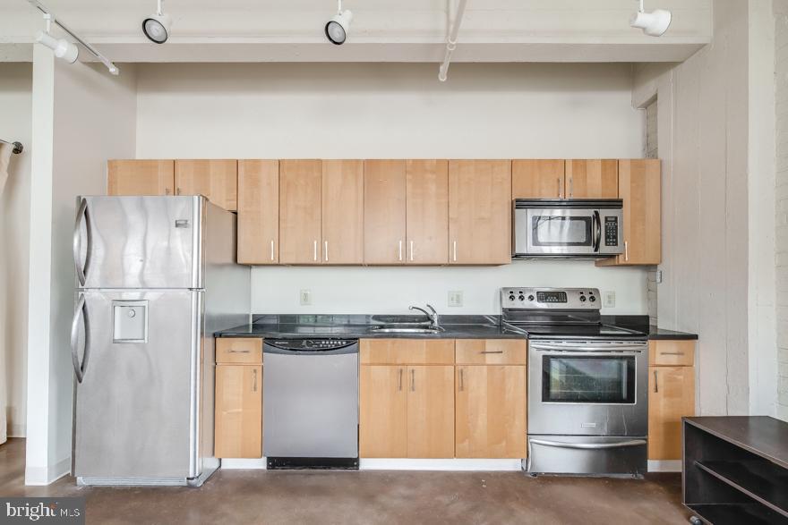 a kitchen with stainless steel appliances granite countertop white cabinets and a refrigerator