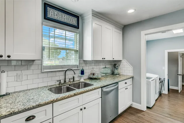 a kitchen with stainless steel appliances granite countertop a sink and a window