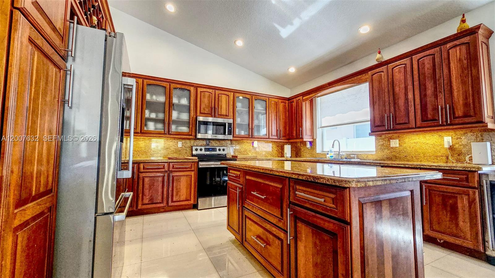 18920 Southwest 29th Street Miramar, FL 33029 - Photo 5 of 6 a kitchen with stainless steel appliances granite countertop wooden cabinets a sink and dishwasher a refrigerator with wooden floor