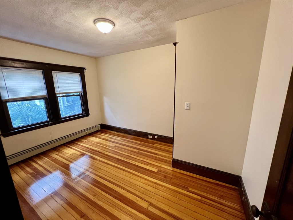 40 Copley Street, Unit 1 Cambridge, MA 02138 - Photo 14 of 21 a view of an empty room with wooden floor and a window