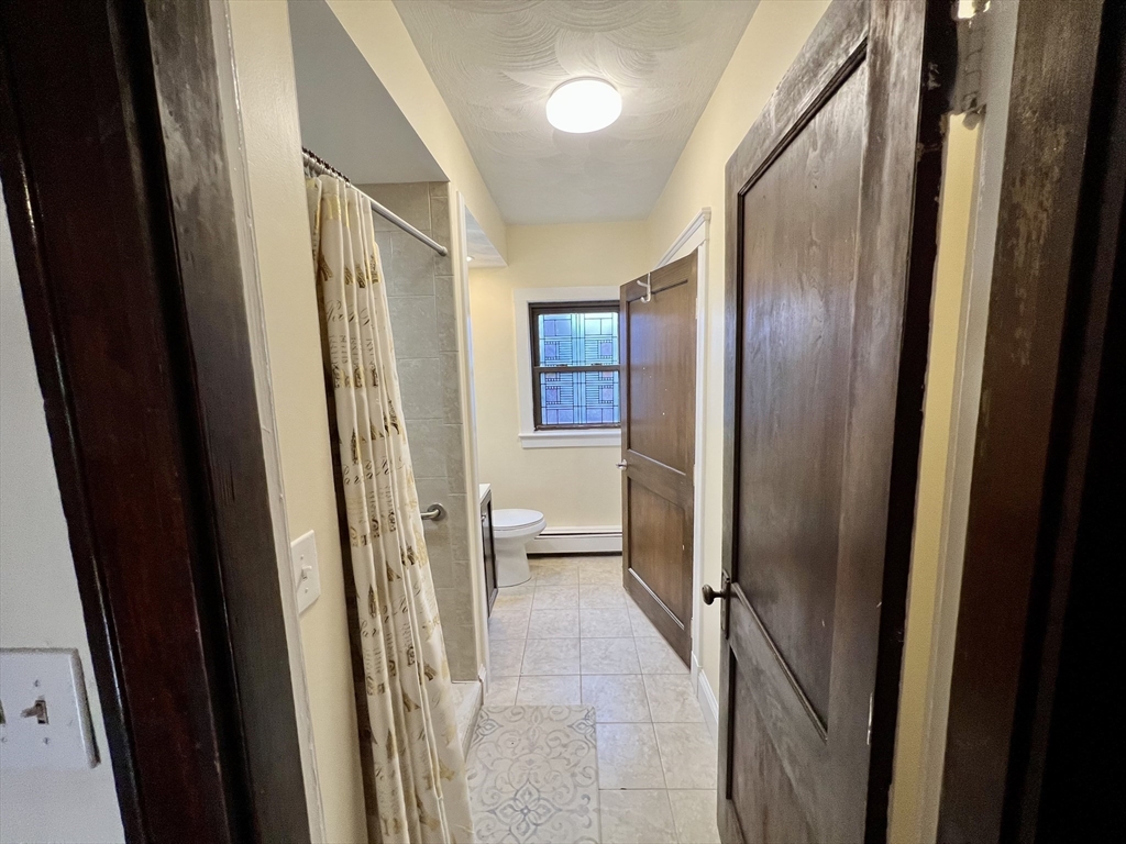 40 Copley Street, Unit 1 Cambridge, MA 02138 - Photo 16 of 21 a bathroom with a glass door shower and a sink
