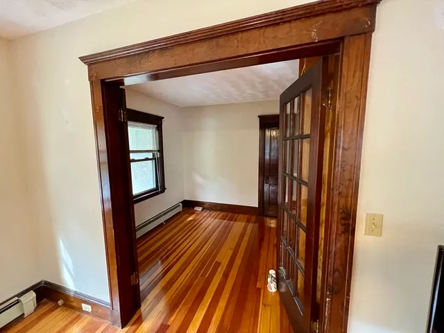 a view of lobby with an empty room and wooden floor