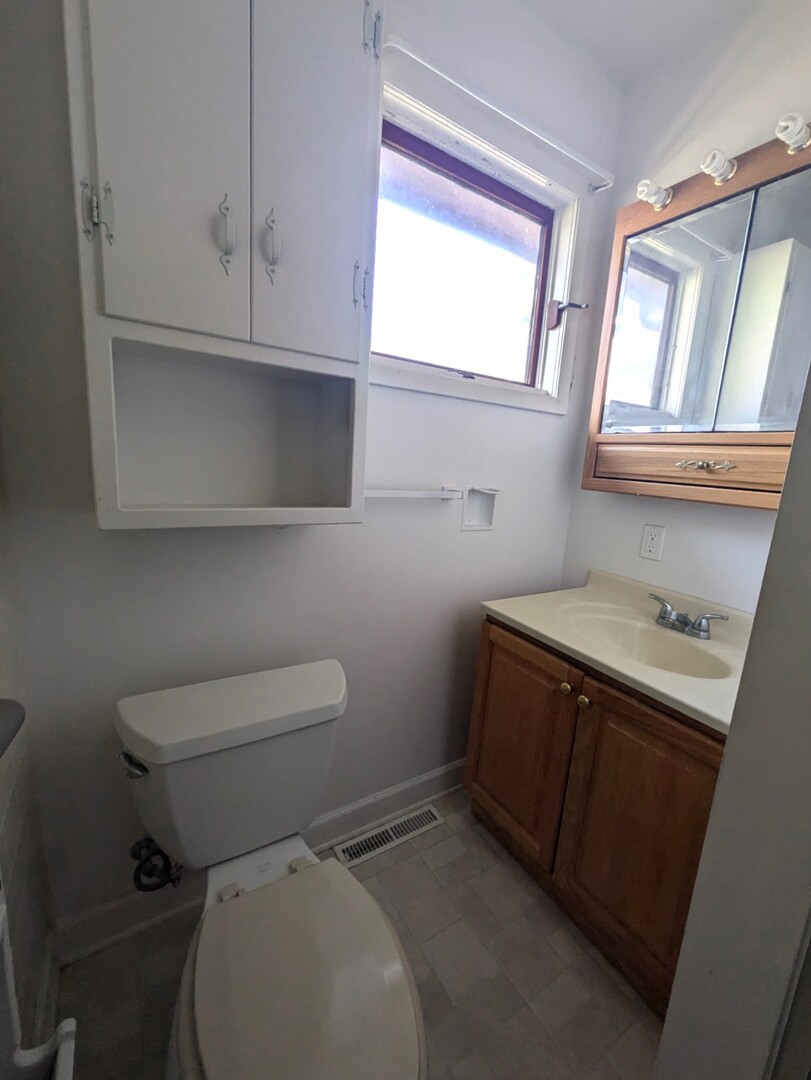 1114 Ash Street Lake In The Hills, IL 60156 - Photo 8 of 8 a bathroom with a toilet sink and window