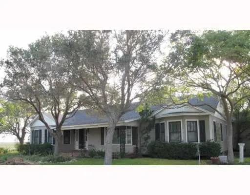 a front view of house with yard and trees around