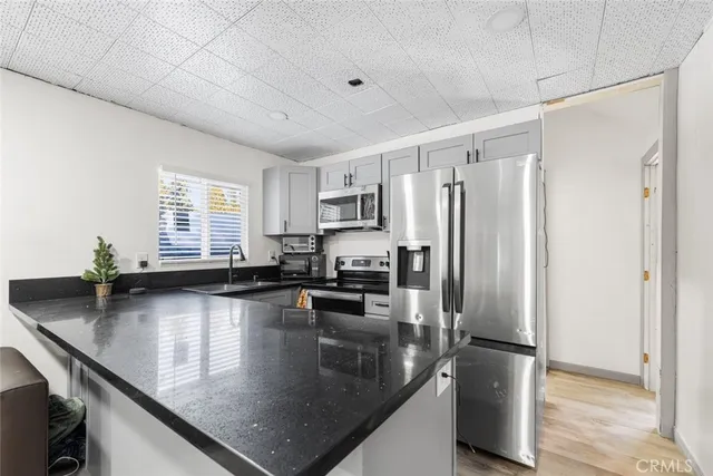 a kitchen with stainless steel appliances granite countertop a sink a stove and a refrigerator