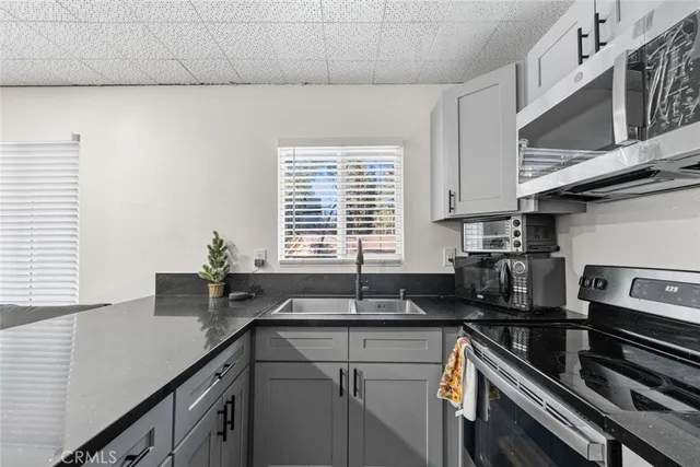 a kitchen with granite countertop a sink stove and cabinets