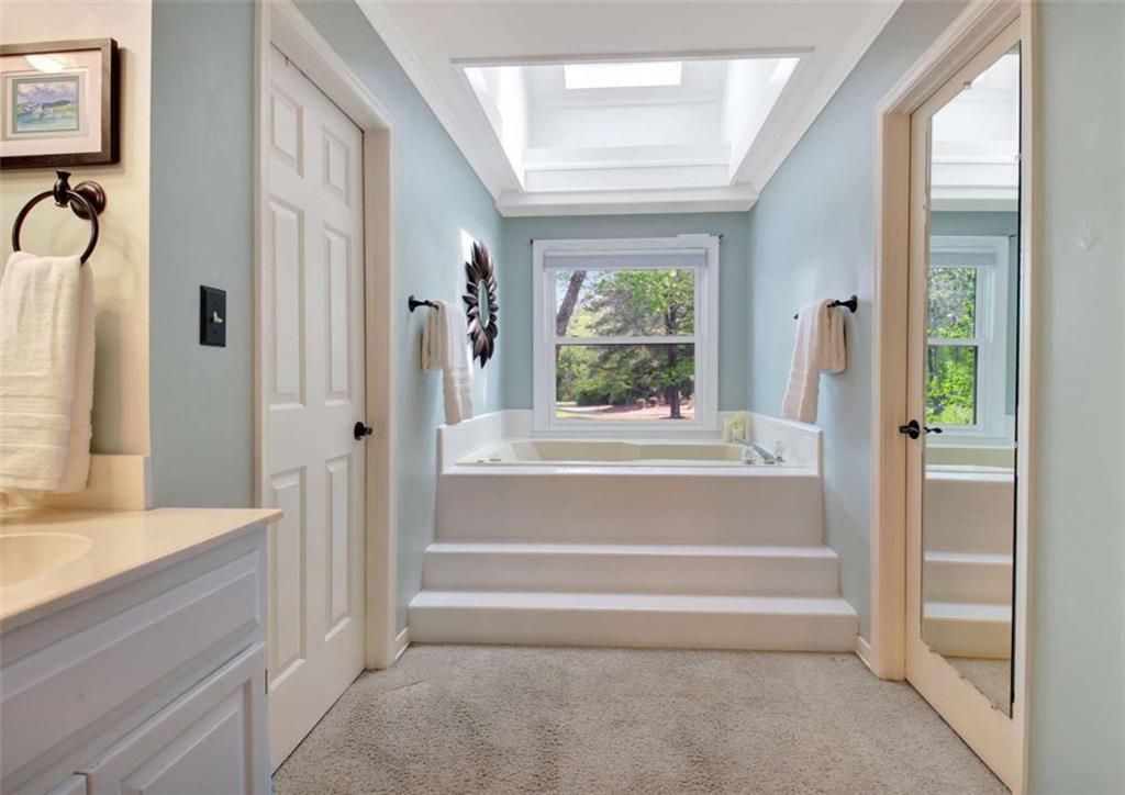 110 Sandtrap Ridge Peachtree City, GA 30269 - Photo 51 of 85 a bathroom with a tub a sink and a window