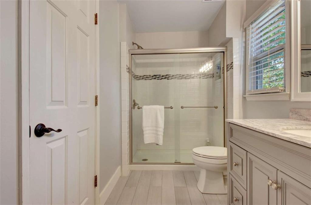 110 Sandtrap Ridge Peachtree City, GA 30269 - Photo 66 of 85 a bathroom with a granite countertop shower a toilet and a shower