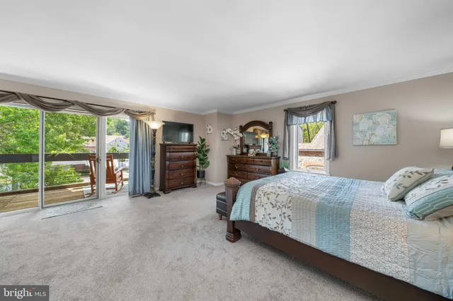 a bedroom with a bed and a large mirror next to a window