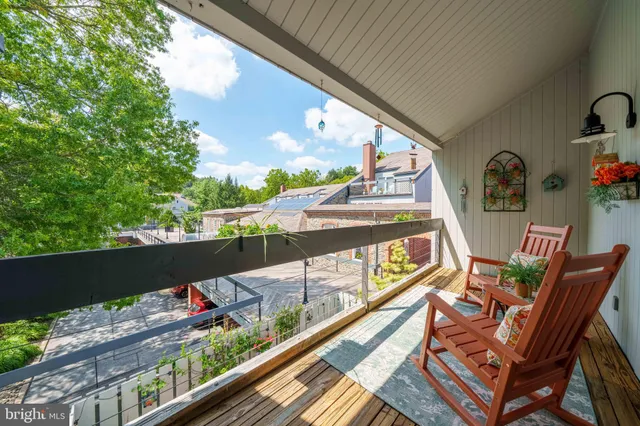 a view of a patio with table and chairs potted plants and floor to ceiling window