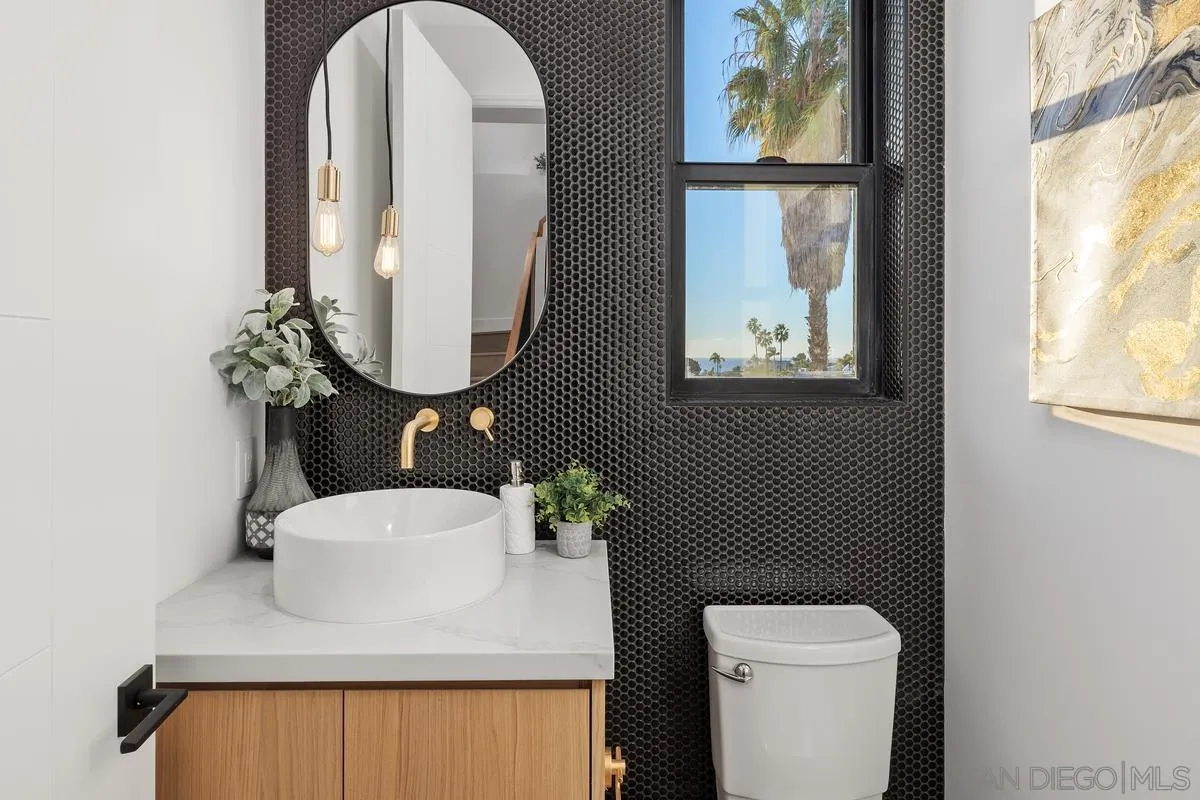 1237 Van Nuys Street San Diego, CA 92109 - Photo 13 of 32 a bathroom with a toilet a sink and a mirror