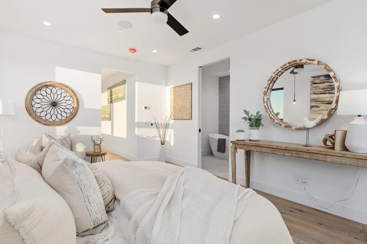 1237 Van Nuys Street San Diego, CA 92109 - Photo 17 of 32 a bedroom with a bed a mirror and clock on the wall