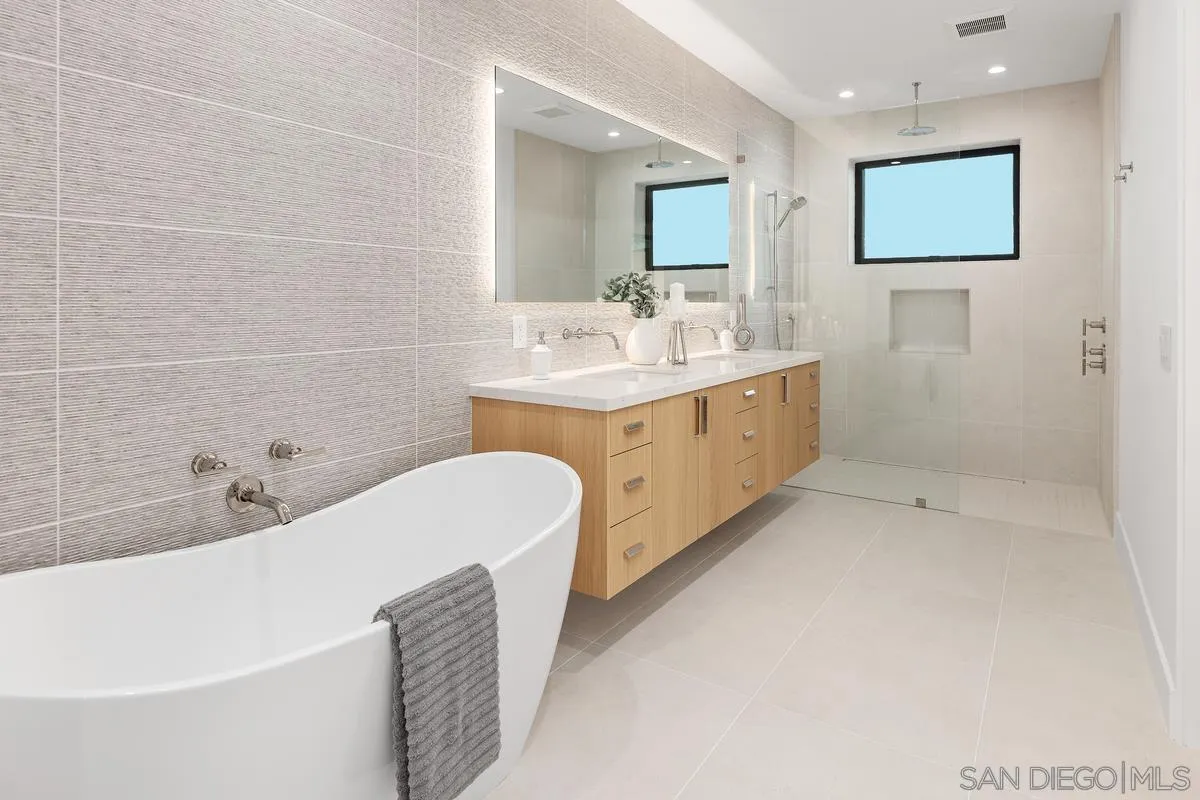 1237 Van Nuys Street San Diego, CA 92109 - Photo 18 of 32 a bathroom with a double vanity sink a toilet and bathtub