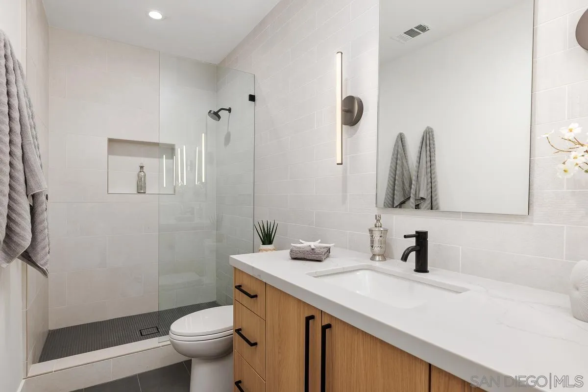 1237 Van Nuys Street San Diego, CA 92109 - Photo 24 of 32 a bathroom with a sink toilet and shower