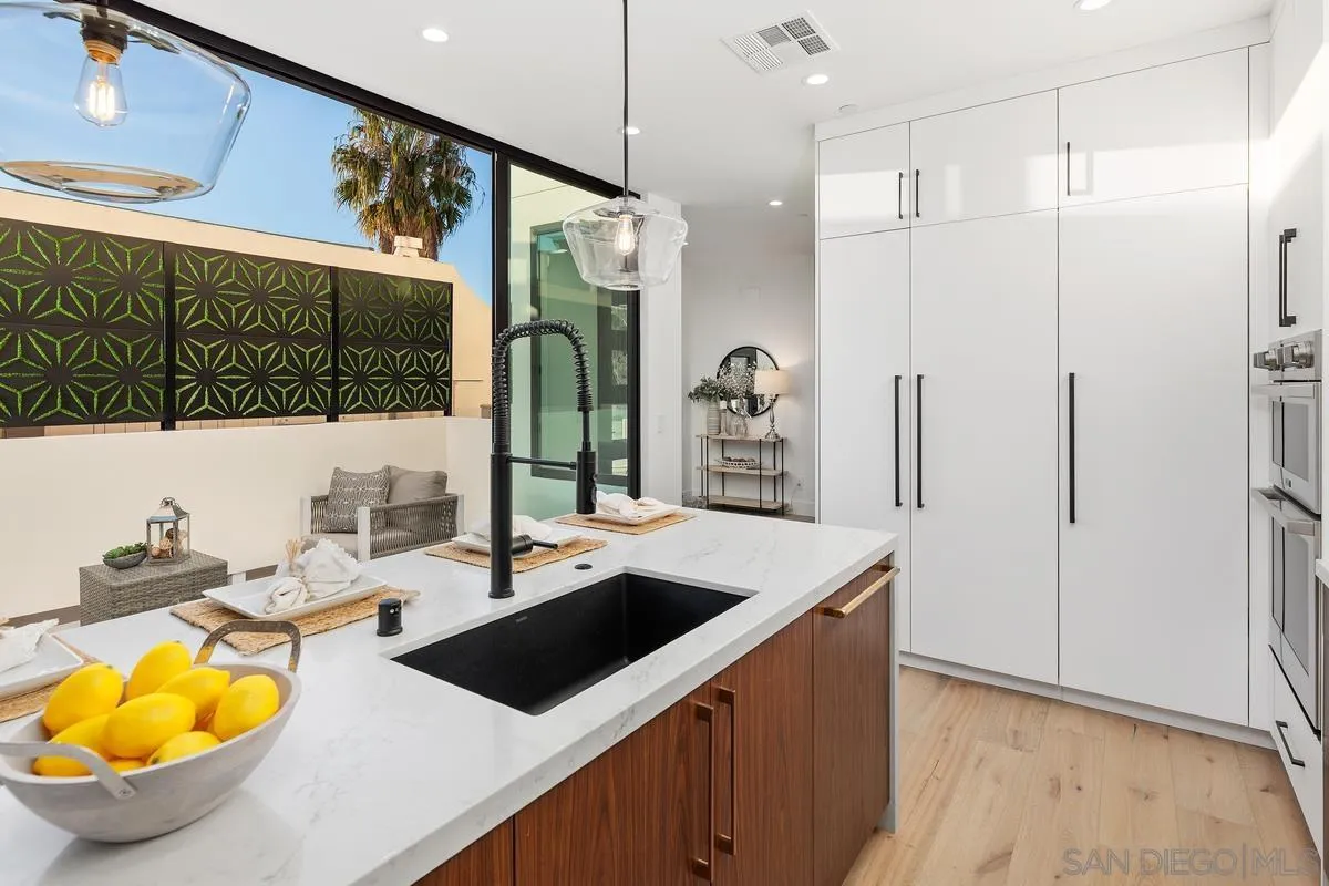 1237 Van Nuys Street San Diego, CA 92109 - Photo 7 of 32 a kitchen with a sink a refrigerator and wooden floor
