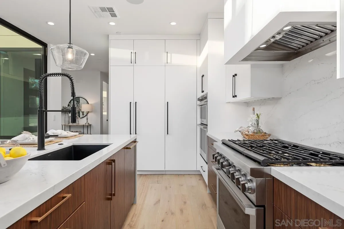 1237 Van Nuys Street San Diego, CA 92109 - Photo 8 of 32 a kitchen with kitchen island stainless steel appliances a sink a stove and a refrigerator