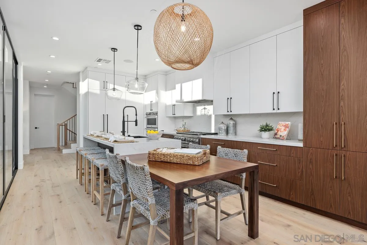1237 Van Nuys Street San Diego, CA 92109 - Photo 9 of 32 a kitchen with stainless steel appliances kitchen island granite countertop a table chairs and a refrigerator