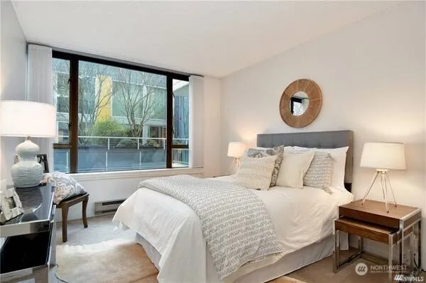 a bedroom with a bed and a large window