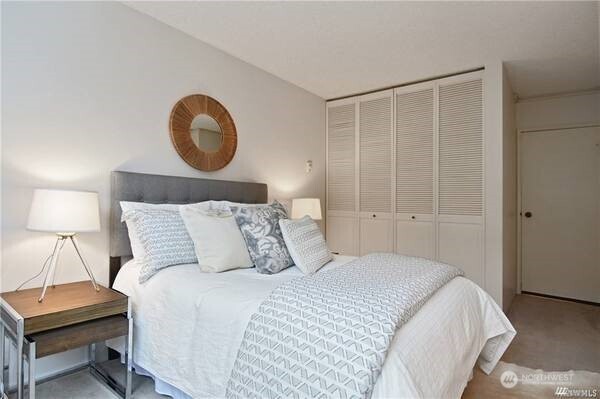 2201 3rd Avenue, Unit 804 Seattle, WA 98121 - Photo 17 of 22 a bedroom with a bed and a lamp on dresser