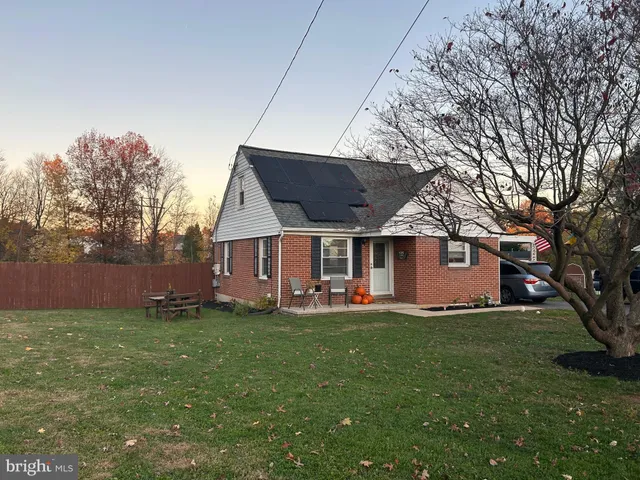 a view of a house with a yard and sitting area
