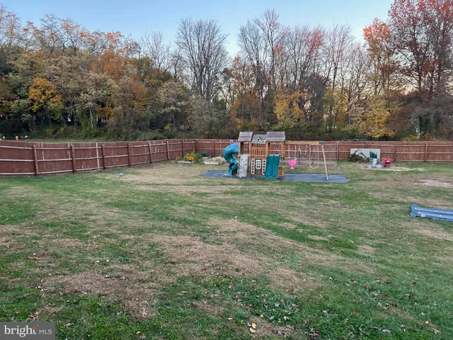 a view of a green field with trees in the background