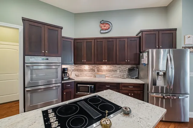 a kitchen with a refrigerator and a stove top oven