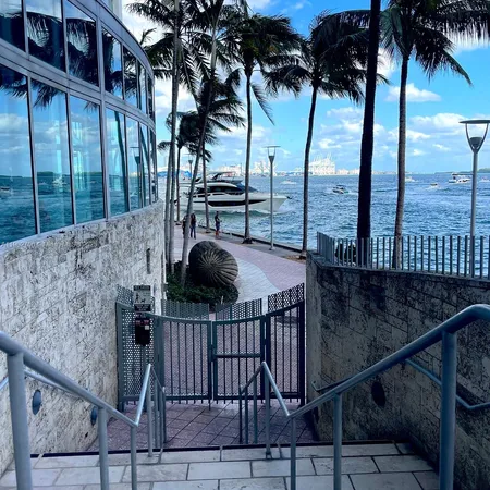 a view of swimming pool with lawn chairs and iron fence