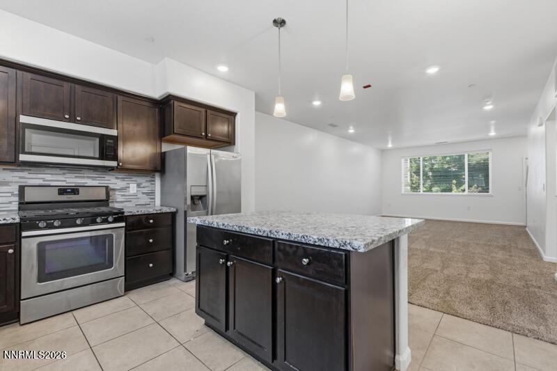 285 Mark Jeffrey Lane Reno, NV 89503 - Photo 4 of 20 a kitchen with stainless steel appliances granite countertop a stove a sink and a microwave