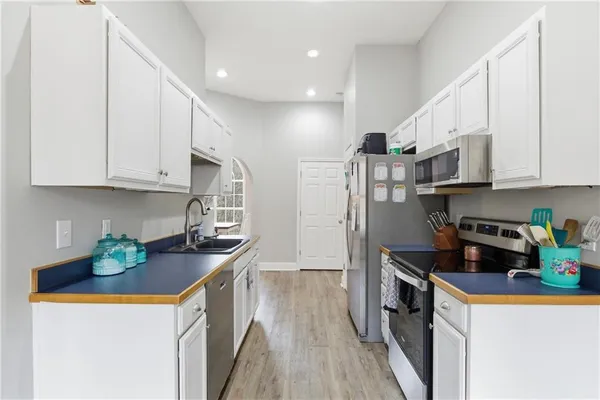 a kitchen with stainless steel appliances granite countertop a refrigerator a stove and a wooden floors