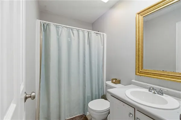 a bathroom with a sink a toilet and shower curtain