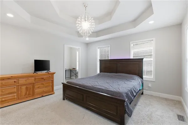 a spacious bedroom with a bed and a flat screen tv