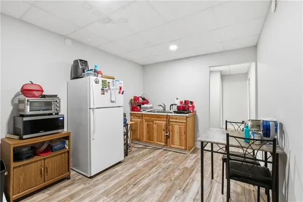 a kitchen with refrigerator a stove and wooden floor