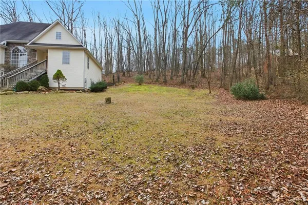 a view of a house with backyard and tree